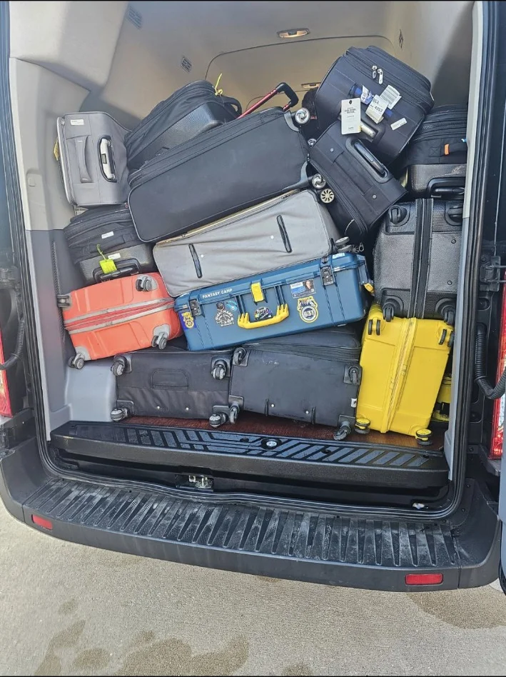 Group Luggage — Van Transfer Planning Passenger van rear cargo area filled with group suitcases of different sizes